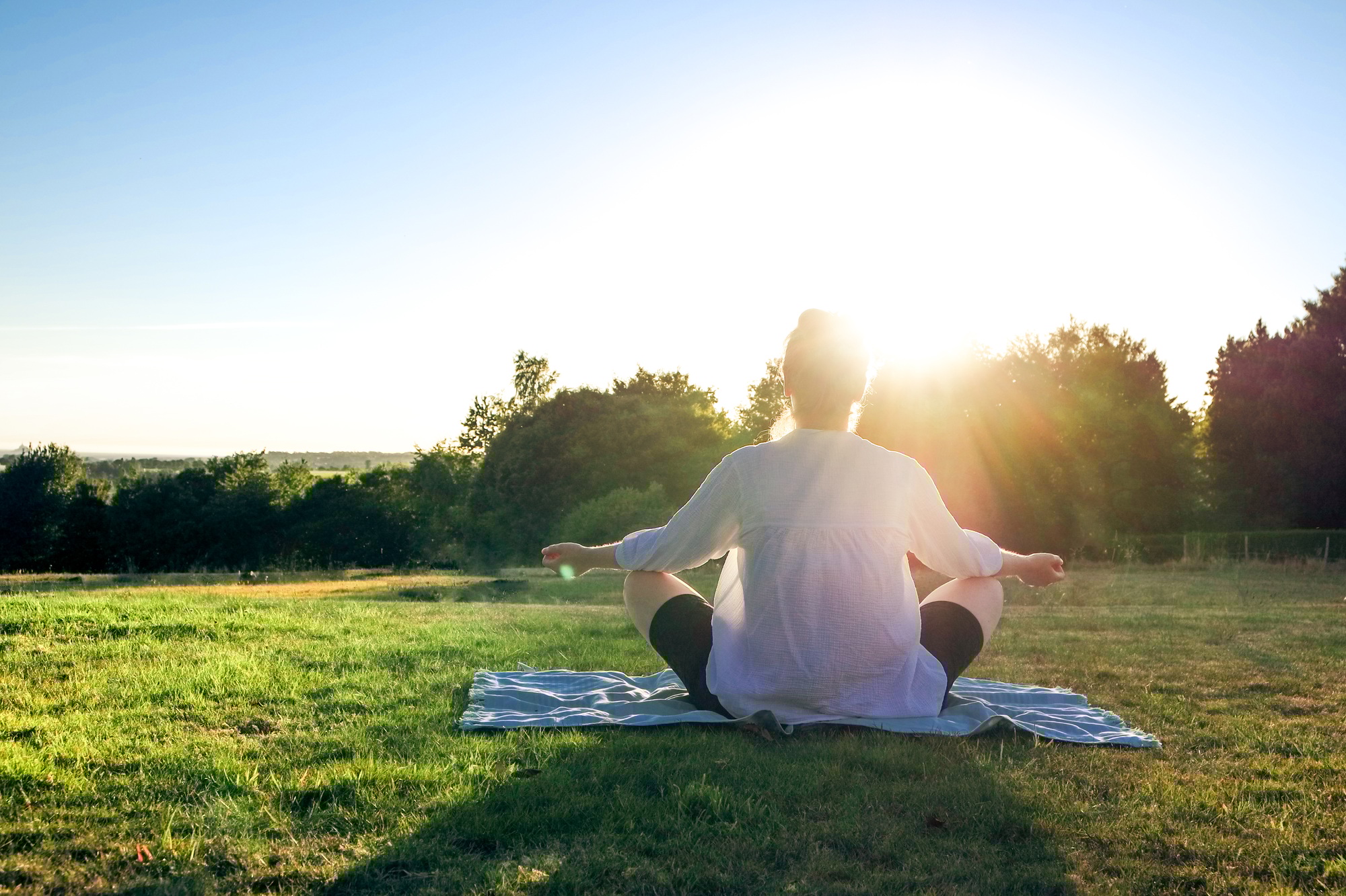 Ältere Frau praktiziert Yoga im Freien.